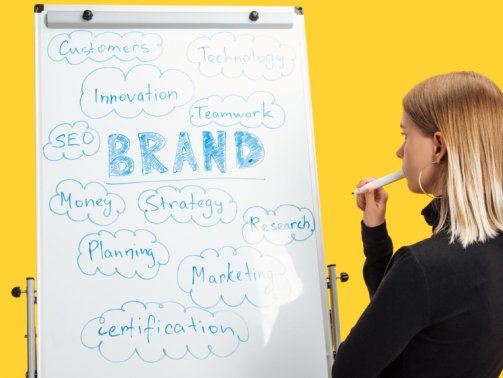 side view of pensive businesswoman standing near white flipchart with words